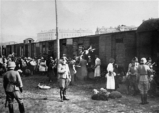 Des Juifs rassemblés sur la Umschlagplatz (la place du transfert) du ghetto de Varsovie embarquent dans des trains en partance pour les camps nazis